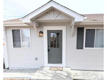 Inviting front entry with a stylish gray door, decorative pediment, and charming exterior lighting fixture at 3419 W Walsh Pl, Denver, CO 80219