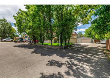 Spacious driveway with mature trees and view of garage and two-story home at 3525 S Brentwood St, Lakewood, CO 80235