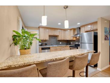 Bright kitchen with stainless steel appliances, wooden cabinets, and granite countertops at 7266 S Birch St, Centennial, CO 80122