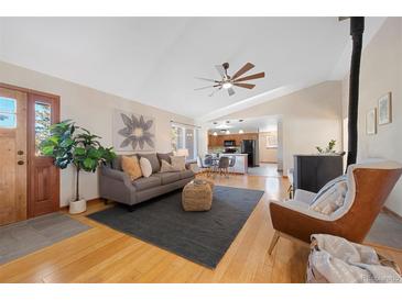 Open-concept living room showcasing hardwood floors, modern decor, and a view into the kitchen at 87 Elmgreen Ln, Evergreen, CO 80439
