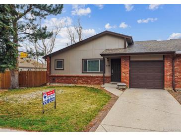 Cozy single-Gathering home featuring brick accents, a driveway, a well-maintained lawn and mature trees at 444 S Larkspur Dr, Castle Rock, CO 80104