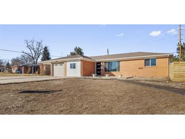 Charming brick home featuring a spacious front yard and an attached two-car garage at 951 E 10Th Ave, Broomfield, CO 80020