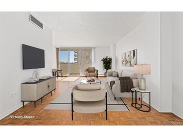 Bright living room with hardwood floors and sliding glass door access to a balcony at 1250 N Humboldt St # 1002, Denver, CO 80218