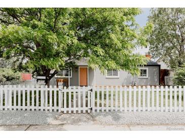 Charming home featuring a well-manicured lawn, a welcoming white picket fence and mature trees for added privacy at 1200 S Patton Ct, Denver, CO 80219