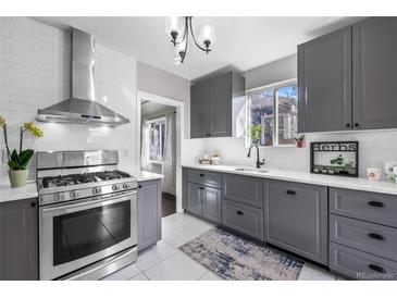 Bright kitchen featuring gray cabinets, white subway tile backsplash, and stainless steel appliances at 3083 Ash St, Denver, CO 80207