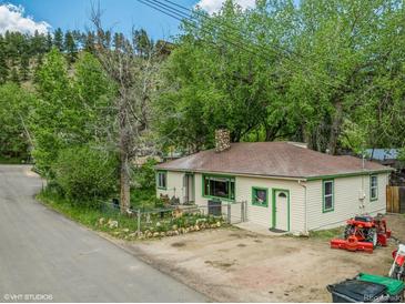 Charming exterior view of home with trees and well-maintained yard at 3384 Avenue F, Kittredge, CO 80457