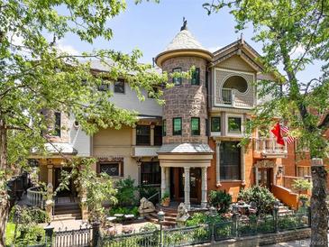 Grand home boasts a stone turret, manicured garden, and stately wrought iron fence at 1022 N Pearl St # 202, Denver, CO 80203