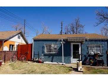 Charming single-story home with blue siding, well-maintained lawn, and detached orange home with wood fence at 3984 N Cook St, Denver, CO 80205