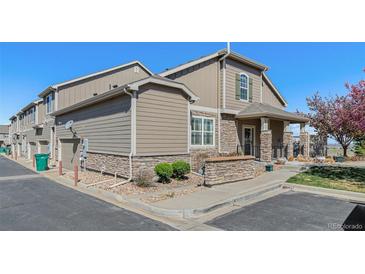 Charming townhome featuring stone accents, well-maintained landscaping, and an attached one car garage at 4739 Raven Run, Broomfield, CO 80023