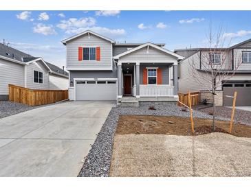 Charming gray two-story home with a cozy front porch and well-maintained landscaping at 9092 Telluride Ct, Commerce City, CO 80022