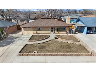 Charming ranch-style home featuring a brick exterior, well-maintained landscaping, and a long driveway at 4713 Cody St, Wheat Ridge, CO 80033