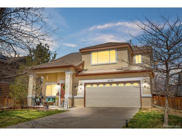Charming two-story home with a well-manicured lawn, a two-car garage, and neutral-colored exterior at 19707 E 59Th Pl, Aurora, CO 80019