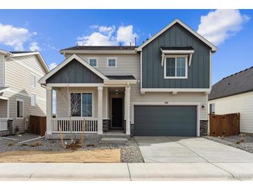 Two-story home featuring a charming front porch, gray siding, well-manicured landscaping, and an attached two-car garage at 190 Lark Sparrow Way, Bennett, CO 80102
