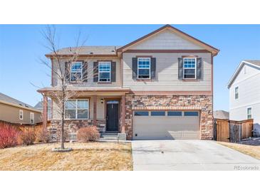 Charming two-story home featuring a brick facade, attached two-car garage, and landscaped front yard at 13673 Valentia St, Thornton, CO 80602