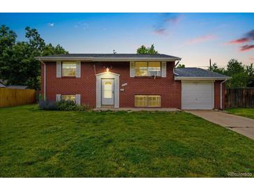 Charming brick home with a well-kept lawn and garden beds enhancing curb appeal at 6721 Quay Ct, Arvada, CO 80003
