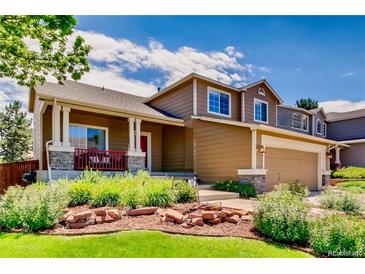 Charming two-story home boasts a lovely front porch and well-manicured landscaping at 9624 Crosspointe Dr, Highlands Ranch, CO 80130