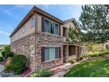 Charming two-story townhouse featuring a stone facade, red shutters, and well-maintained landscaping at 22920 E Roxbury Dr # H, Aurora, CO 80016