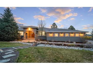Stunning home exterior with bridge to front door and beautifully landscaped front yard at 5631 Silver Bluff Ct, Parker, CO 80134