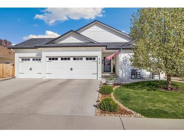 Charming single-story home featuring a three-car garage, manicured lawn, and American flag at 410 Clover Ct, Frederick, CO 80530