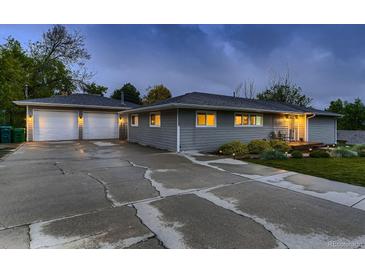Charming home with a two-car garage and spacious cracked driveway at dusk at 1100 E Harvey St, Castle Rock, CO 80108