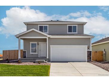 Charming two-story home featuring a gray exterior, attached two-car garage, and a well-maintained lawn and landscaping at 48290 Shetland Dr, Bennett, CO 80102
