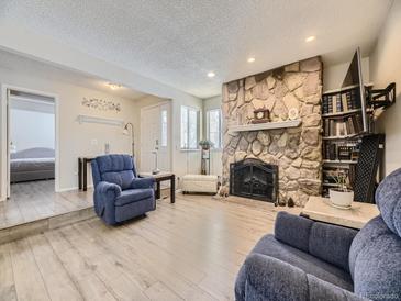 Living room with stone fireplace and hardwood floors at 2630 S Xanadu Way # C, Aurora, CO 80014