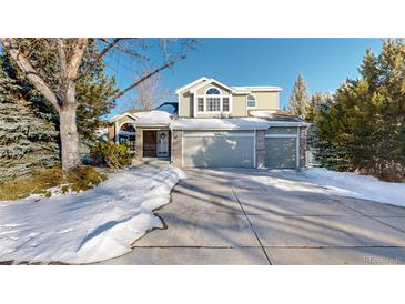 Two-story house with attached garage and snow-covered front yard at 6990 Orchard Ct, Arvada, CO 80007