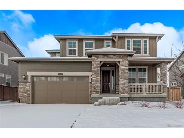 Two-story home featuring a welcoming front porch, a two car garage and beautiful stonework accents at 14769 Dahlia St, Thornton, CO 80602