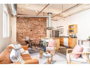 Open concept living space with exposed brick, stainless steel appliances, and modern furnishings at 1777 E 39Th Ave # 209, Denver, CO 80205