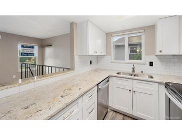 Bright kitchen features granite countertops, white cabinets and subway tile backsplash at 10001 E Evans Ave # D, Aurora, CO 80247
