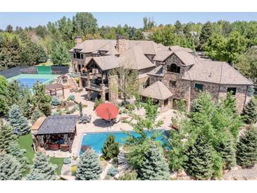 Expansive property with a pool, tennis court, stone patio, and mature trees at 5650 E Stanford Dr, Cherry Hills Village, CO 80111