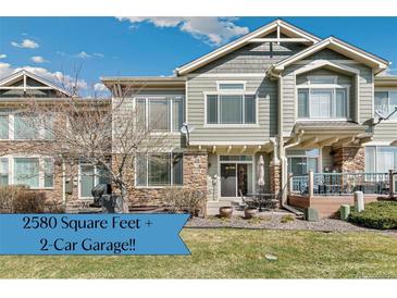 Charming townhome featuring a combination of stone and siding, coupled with a well-maintained lawn and patio, offering great curb appeal at 15064 E Crestridge Dr, Centennial, CO 80015