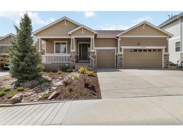 Charming home featuring a two-car garage, landscaped yard, and inviting front porch at 2724 Rising Moon Way, Castle Rock, CO 80109