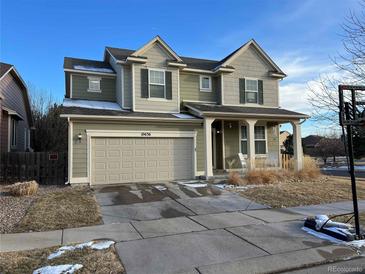 Two story home featuring a large front yard and a two car garage at 10636 Racine Cir, Commerce City, CO 80022