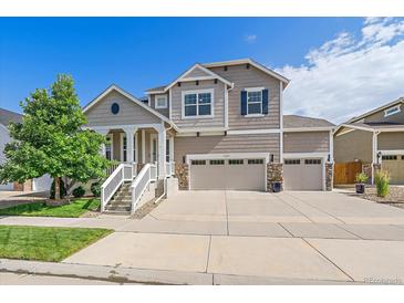 Charming two-story home with a three-car garage, landscaped yard, and inviting front porch at 15201 Yellowthroat St, Parker, CO 80134