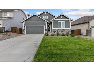 Gray exterior boasts a two-car garage and well-manicured lawn at 3037 Lake Helen Blvd, Mead, CO 80542