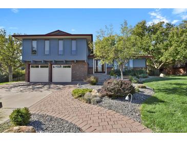 Two-story home with brick and blue siding, a paved walkway, and landscaped yard at 5357 S Cimarron Rd, Littleton, CO 80123