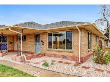 Charming single-story brick home featuring a well-maintained front yard and a cozy, covered entry, full of character at 3690 N Hudson St, Denver, CO 80207