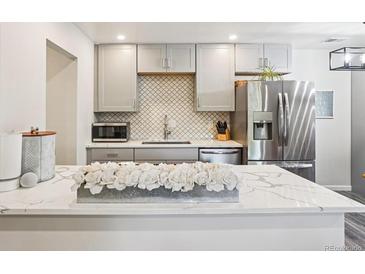 Modern kitchen featuring stainless steel appliances, white cabinets, and white countertops at 7995 E Mississippi Ave # F23, Denver, CO 80247