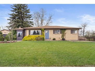 Charming brick home with a well-manicured lawn and landscaping in a peaceful neighborhood setting at 865 S Everett St, Lakewood, CO 80226