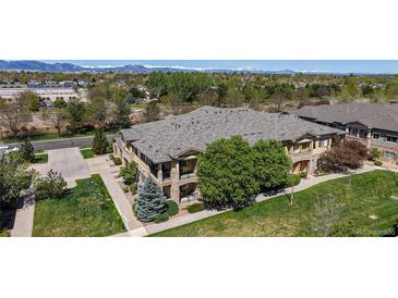 Stunning aerial view of a two-story home with lush landscaping and mountain views on a sunny day at 11374 Xavier Dr # 202, Westminster, CO 80031