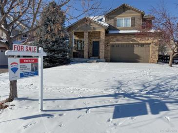 Two-story house with a two-car garage and snow-covered front yard at 23541 E Portland Way, Aurora, CO 80016