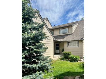 Charming two-story home with a well-manicured lawn, beautiful landscaping, and welcoming front entrance at 10369 E Red Mtn, Littleton, CO 80127