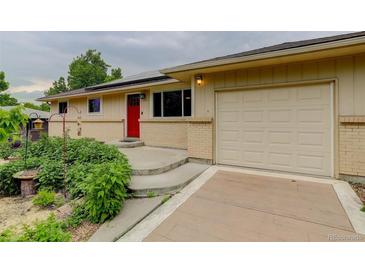 Charming single-story home featuring a red front door and an attached one car garage at 9743 W 67Th Pl, Arvada, CO 80004