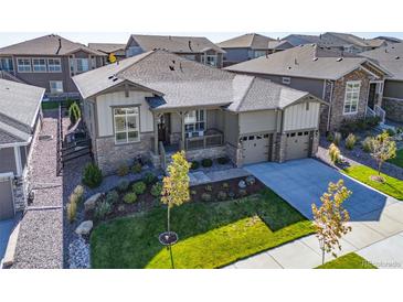 Charming single-Gathering home with a manicured lawn, a covered porch, and a two-car garage at 21972 E Allenspark Dr, Aurora, CO 80016