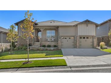 Charming home with covered porch, stone accents, two-car garage, and well-maintained landscaping at 21972 E Allenspark Dr, Aurora, CO 80016