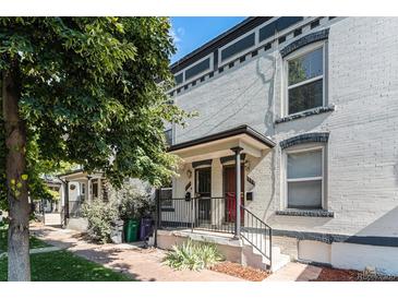 Charming white brick home with black trim and landscaped yard, located in a desirable neighborhood at 723 31St St, Denver, CO 80205