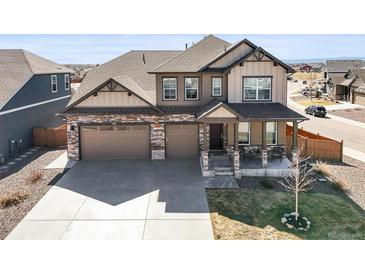 Stunning two-story home featuring a covered porch, a three-car garage and beautiful stone and siding accents at 1624 Pinion Wing Cir, Castle Rock, CO 80108