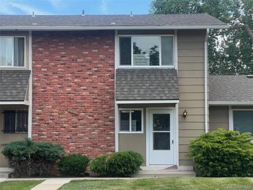 Charming brick and siding townhouse with a well-maintained lawn and mature shrubs at 2218 Coronado N Pkwy # B, Denver, CO 80229
