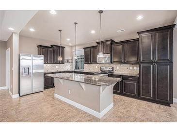 Spacious kitchen features granite countertops, stainless steel appliances, and dark wood cabinets at 5521 Ensenada St, Denver, CO 80249